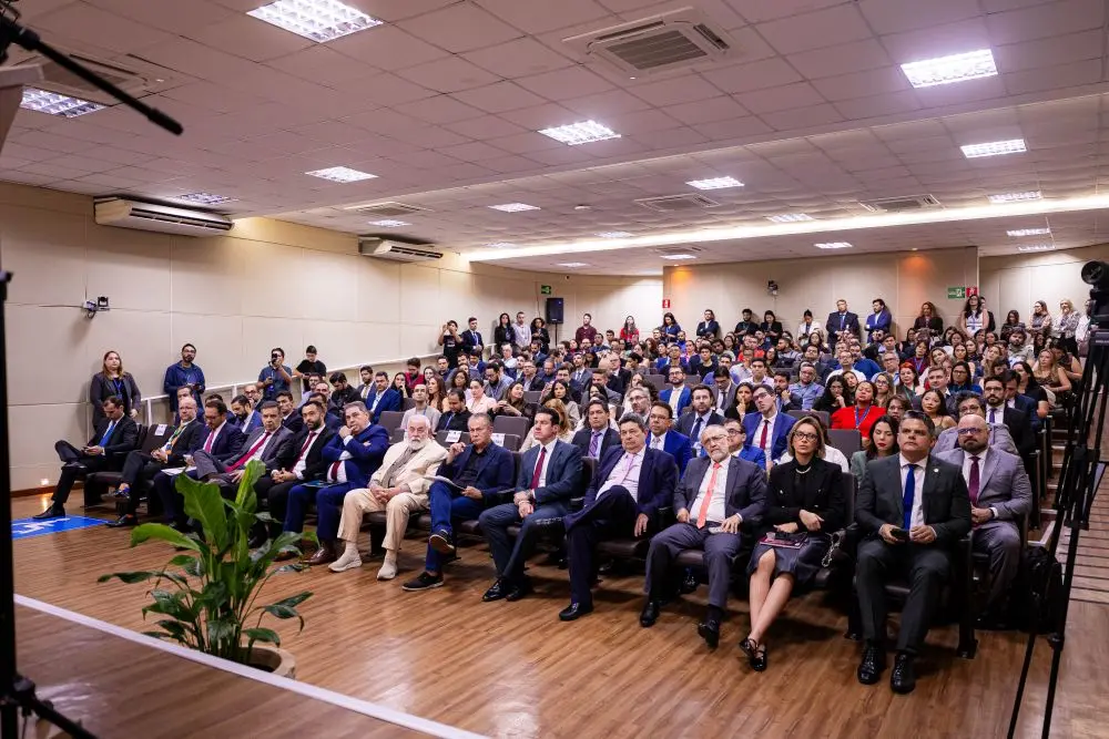 Foto horizontal em plano aberto que mostra a plateia lotada no auditório do Tribunal de Justiça. 